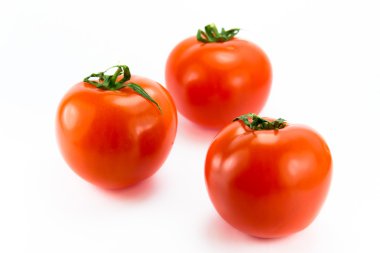 Three red ripe tomaterpå a white background