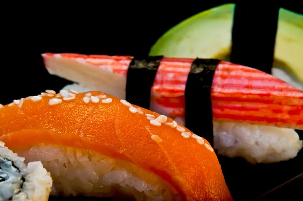 Four sushi on a black background — Stock Photo, Image