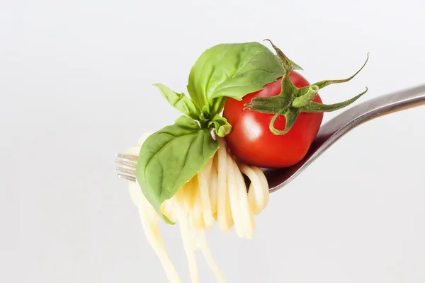 Spaghetti with tomato and basil on fork — Stok fotoğraf