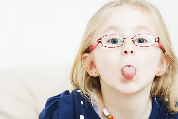 Klein meisje steekt haar tong uit Stockafbeelding