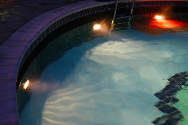 Pool with blue water at night clipart