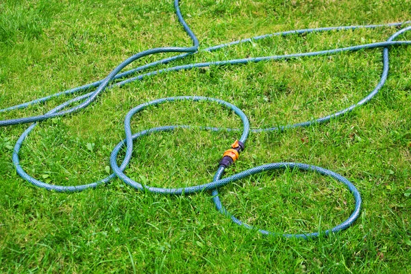 Wąż z tworzywa sztucznego na zielonej trawie — Zdjęcie stockowe