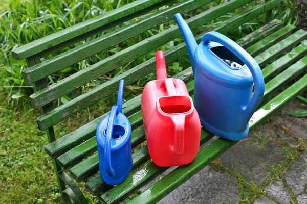 Watering cans in garden — Stock Photo, Image
