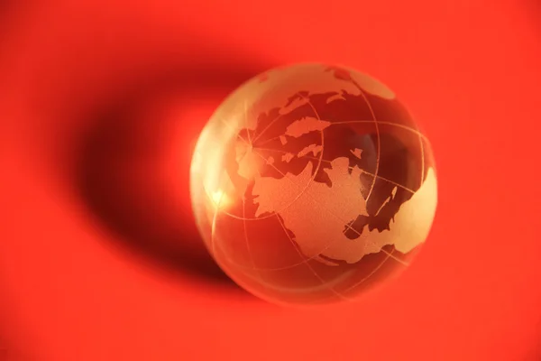 Globus auf rotem Hintergrund — Stockfoto