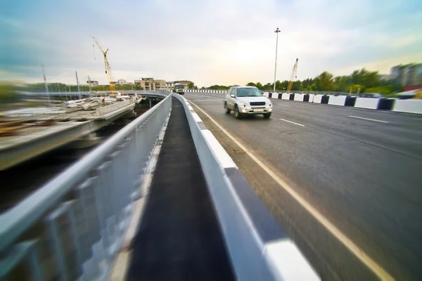 Auto in corso sul nuovo ponte in città — Foto Stock