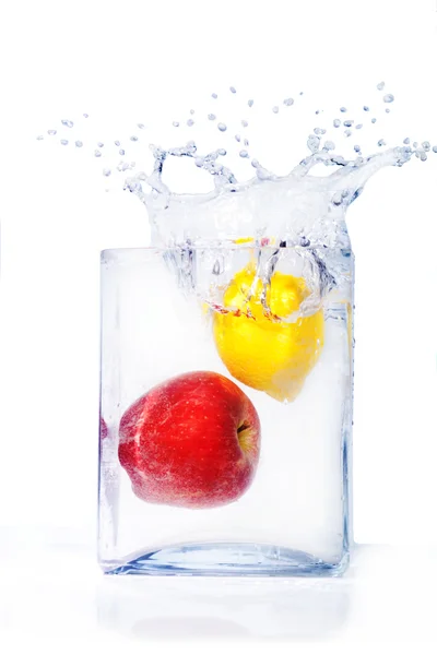 Яблоко и лимон в воде и брызги — стоковое фото