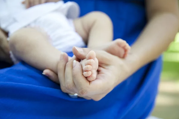 Nyfödd baby fötter i mors händer — Stockfoto