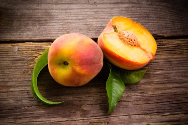 Fresh organic fruit - peaches on wood background clipart