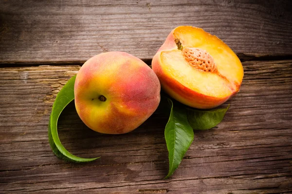 Fresh organic fruit - peaches on wood background — Stock Photo, Image
