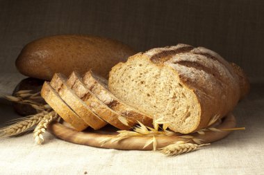 Fresh bread on wooden plate clipart