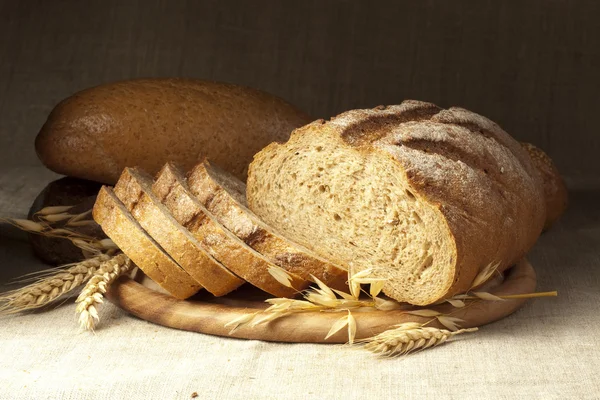 Färskt bröd på träplatta — Stockfoto