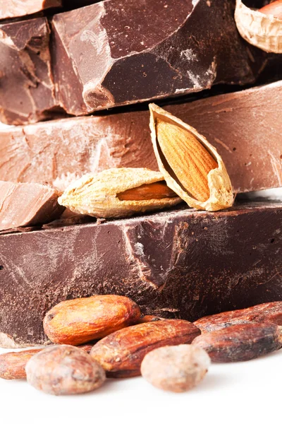 Mängd choklad. bitar med kakaobönor och mandel nötter — Stockfoto