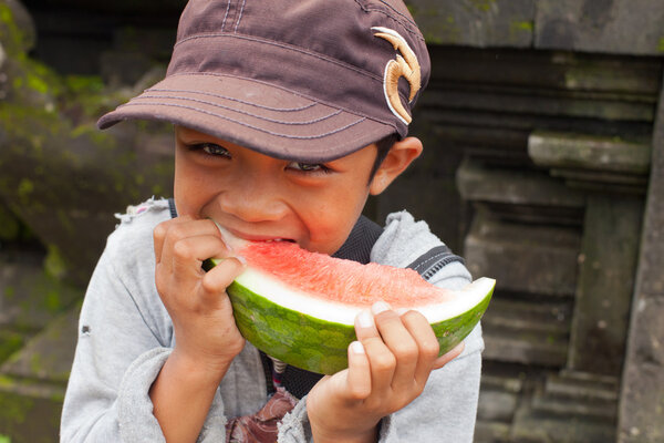 Balinese boy eating watermelon