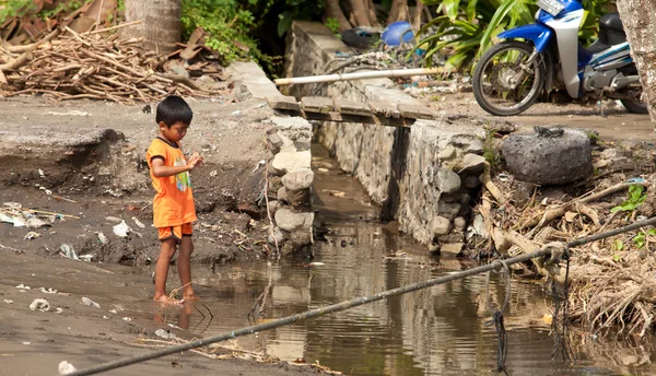 Kid i smutsigt vatten — Stockfoto