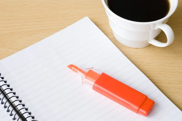 Caderno espiral com xícara de café e iluminador — Fotografia de Stock