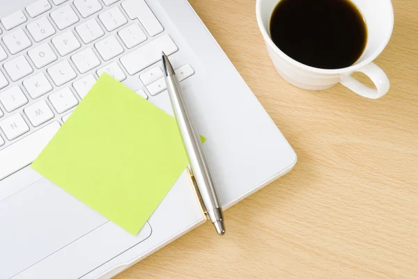 Pen met postit opmerking, laptop en kopje koffie — Stockfoto