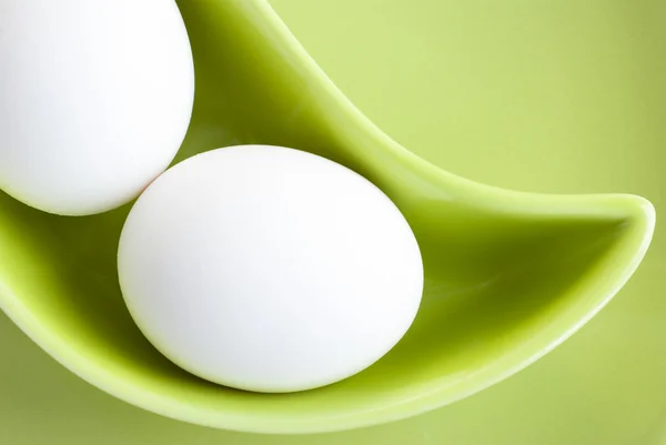 Fehér tojás található egy zöld csészealj — Stock Fotó