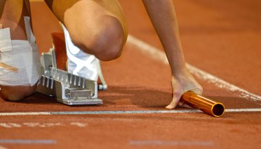 Relay runner in the starting blocks clipart