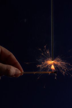 Hand lighting a sparkler clipart