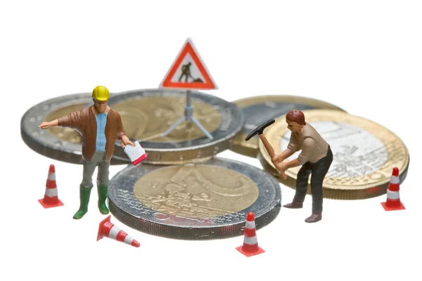 Figuras en miniatura trabajando en un montón de monedas de euro . — Foto de Stock