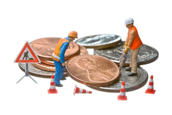 Miniatuurfiguren werken op een hoop van dollar munten. — Stockfoto