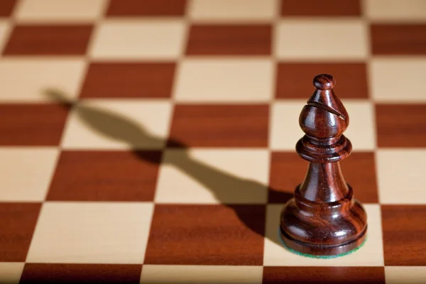 Шахматная фигура - черный слон на шахматной доске . — стоковое фото