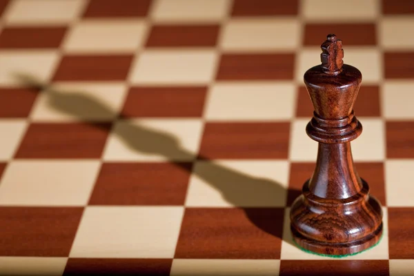 Satranç taşını - bir satranç tahtası üzerinde siyah bir kral. — Stok fotoğraf