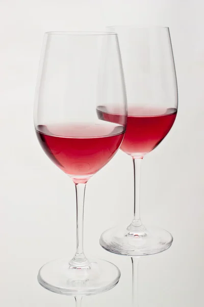 Two glasses of red wine in soft white light — Stock Photo, Image
