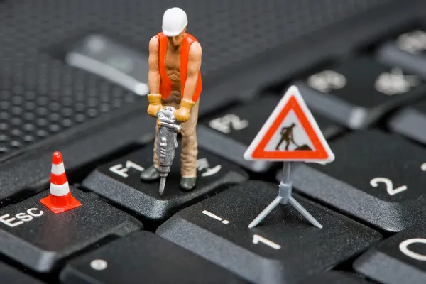 Miniatuurfiguren werken op een computertoetsenbord. Stockfoto