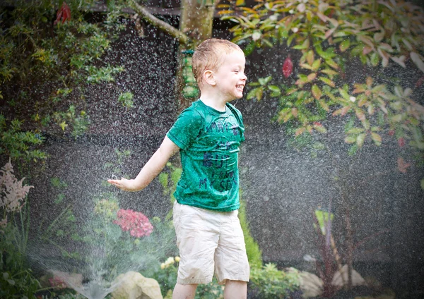 Маленький мальчик играет под дождем — стоковое фото