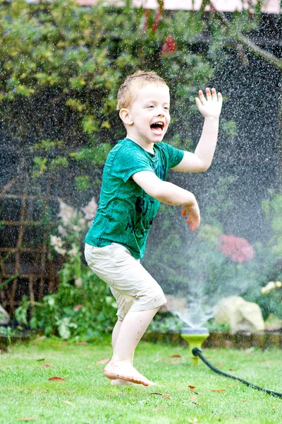 Boy playing in the spray — Stock Photo, Image