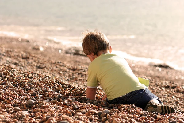 Little boy at a stony beach — Stock Photo, Image
