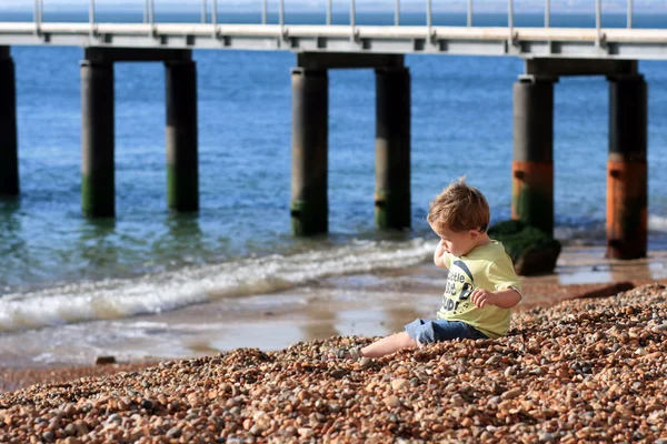 Kleiner Junge an einem steinigen Strand — Stockfoto