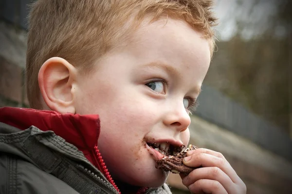 Liten pojke som äter en cookie — Stockfoto