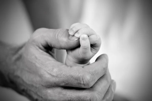 パパ赤ちゃんの娘の手を握って ロイヤリティフリーのストック画像