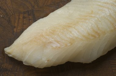 Raw Cod on a wooden butcher clipart