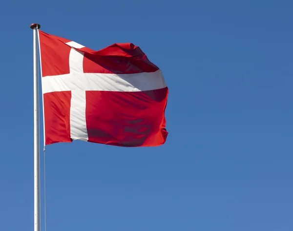 Le drapeau danois, Dannebrog, contre un ciel bleu Photos De Stock Libres De Droits
