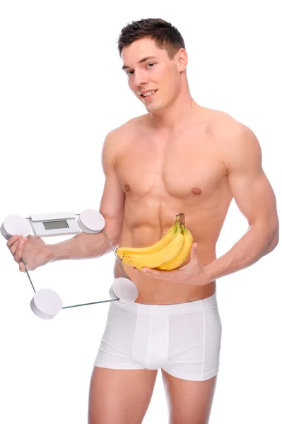 Мужчина с весами в ванной и бананом — стоковое фото