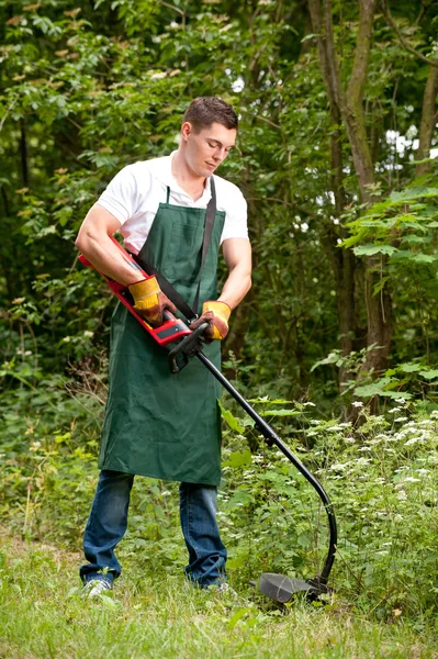 Jardineiro com aparador de relva — Fotografia de Stock