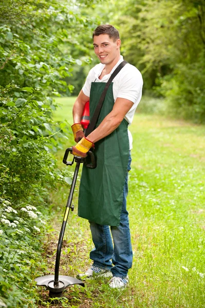 Jardineiro com aparador de relva — Fotografia de Stock