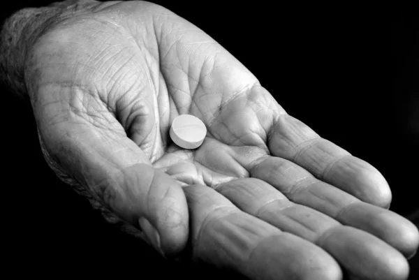 Mão velha com pílula — Fotografia de Stock