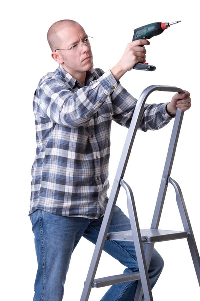 Craftsman on a ladder with a cordless screwdriver — Stok fotoğraf