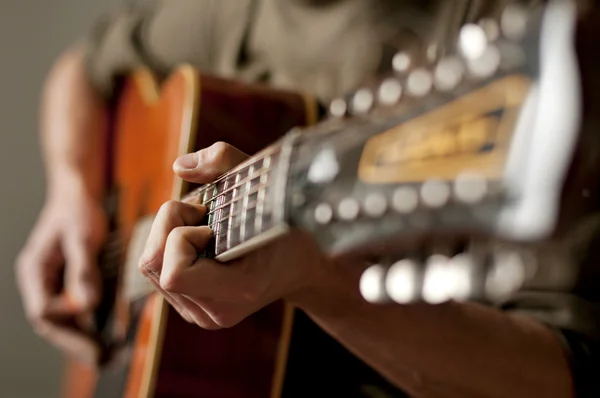 Spela en 12 strängad akustisk gitarr — Stockfoto
