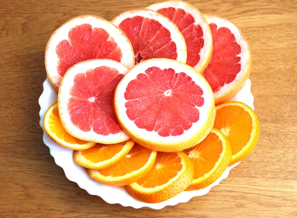 Anneaux de pamplemousse et d'orange sur une assiette blanche — Photo