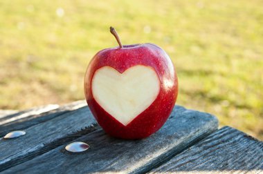 Lonely apple with carved heart clipart