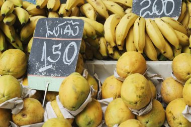 Bananas and papaya in a street market clipart