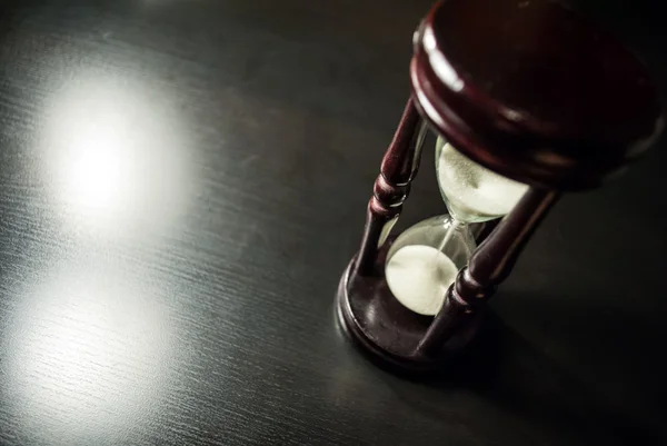 stock image Hourglass in a dark wood