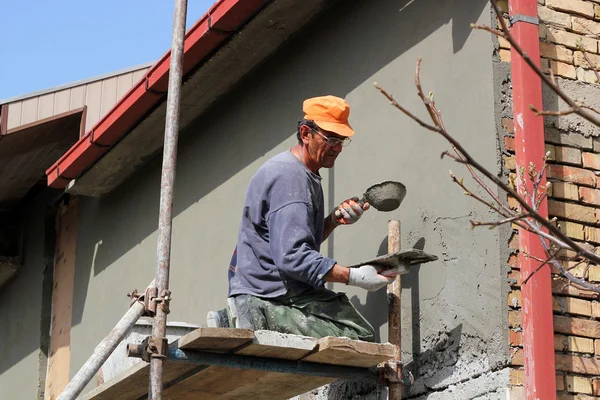 Arbeiter verputzt eine Wand — Stockfoto