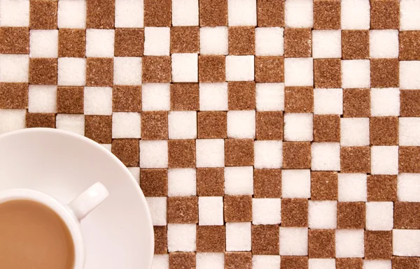 Tasse de café avec sucre sur des tourbes blanches et brunes de sucre . — Photo