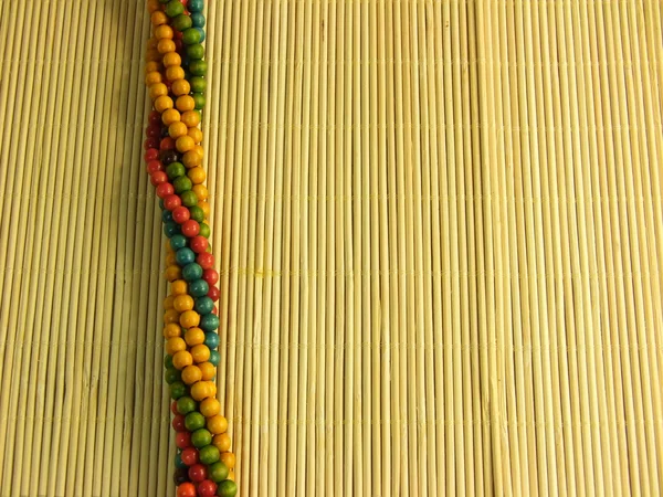 Bijoux colorés en bois sur table en bambou — Photo